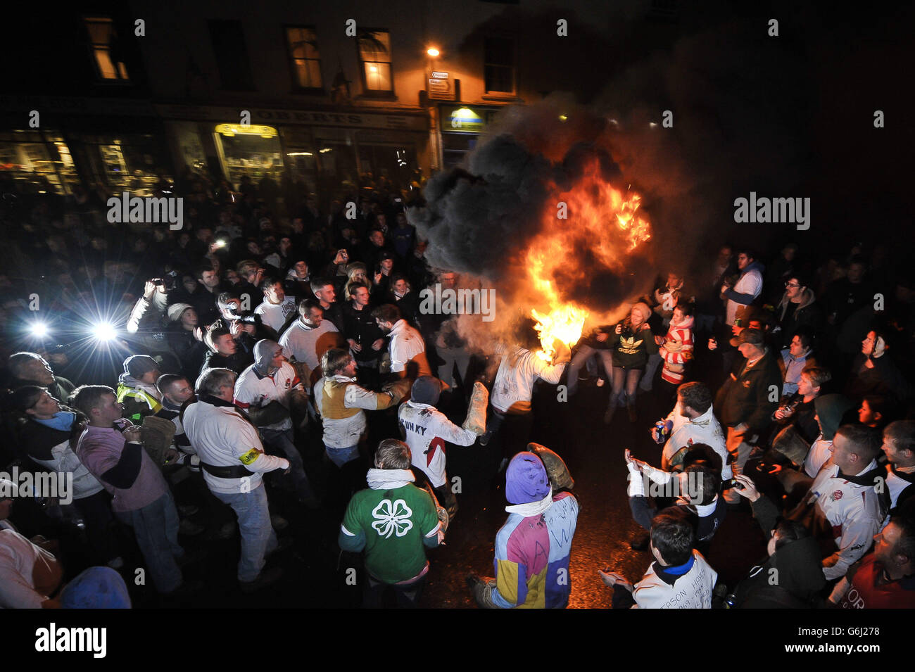 Les adultes du village Devonshire d'Ottery St Mary portent le Tar Barrel traditionnel à travers les rues du village la nuit de Bonfire. Banque D'Images