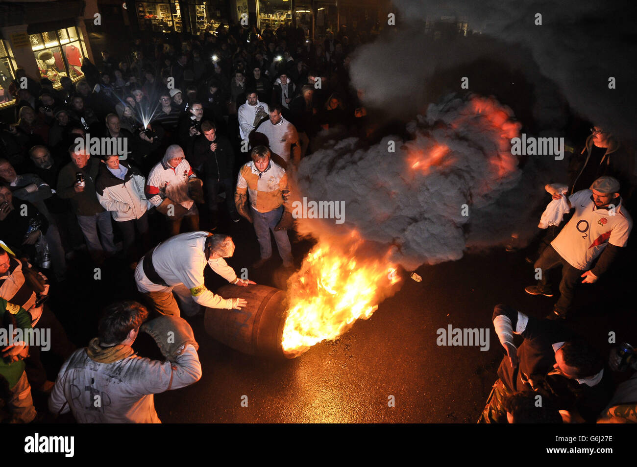 Les adultes du village Devonshire d'Ottery St Mary portent le Tar Barrel traditionnel à travers les rues du village la nuit de Bonfire. Banque D'Images