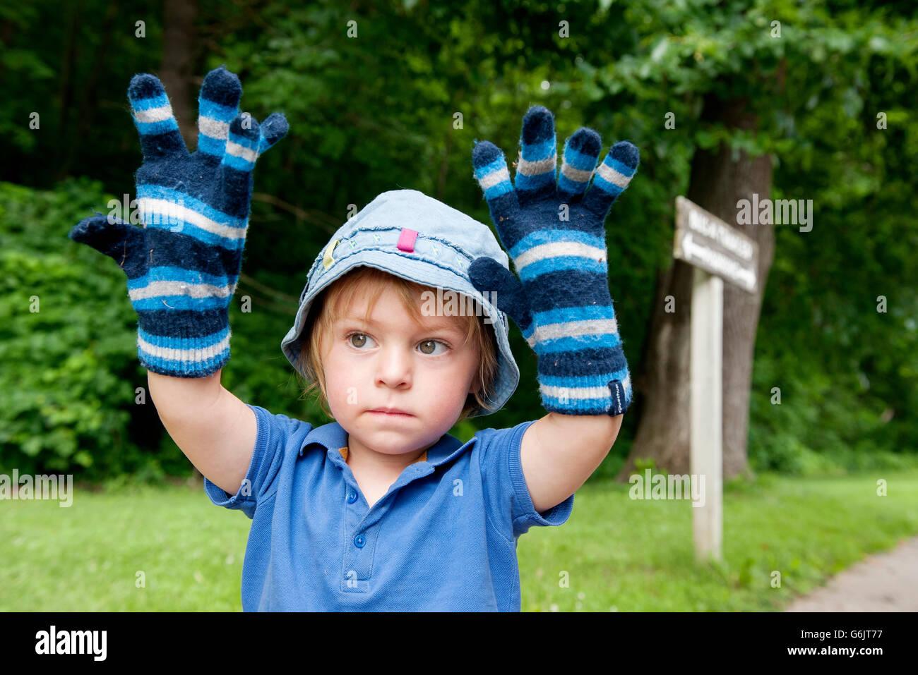 Little Boy wearing oversized Gants hiver, portrait Banque D'Images