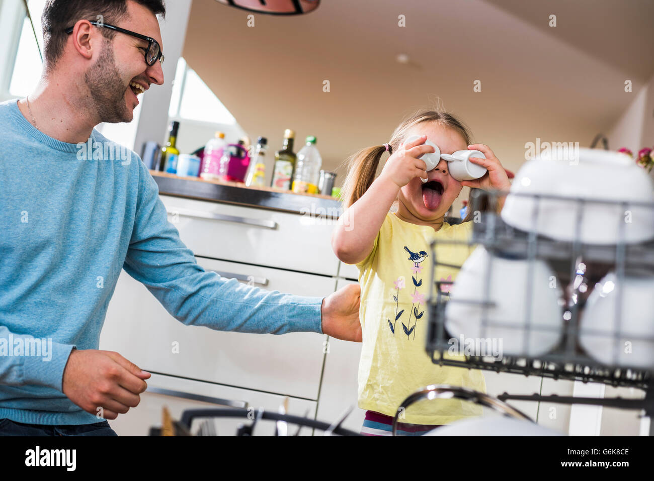 Père et fille espiègle clearing lave-vaisselle Banque D'Images