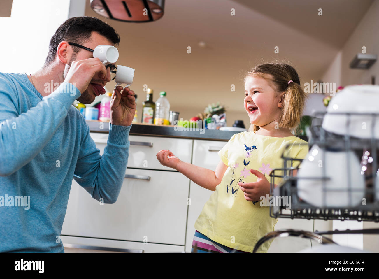 Père et fille espiègle clearing lave-vaisselle Banque D'Images
