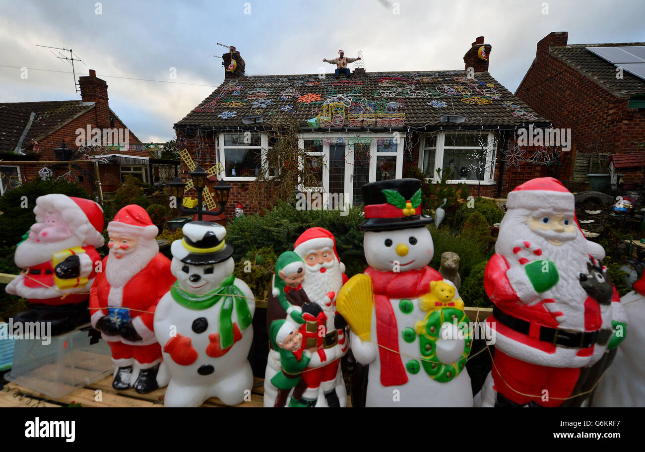 Eric Marshalls, 73 ans, sur le toit de sa maison à Bagby, dans le Yorkshire du Noth, Eric passe jusqu'à trois semaines à ériger son exposition de lumières de Noël qu'il a amassées pendant plus de 20 ans. Banque D'Images