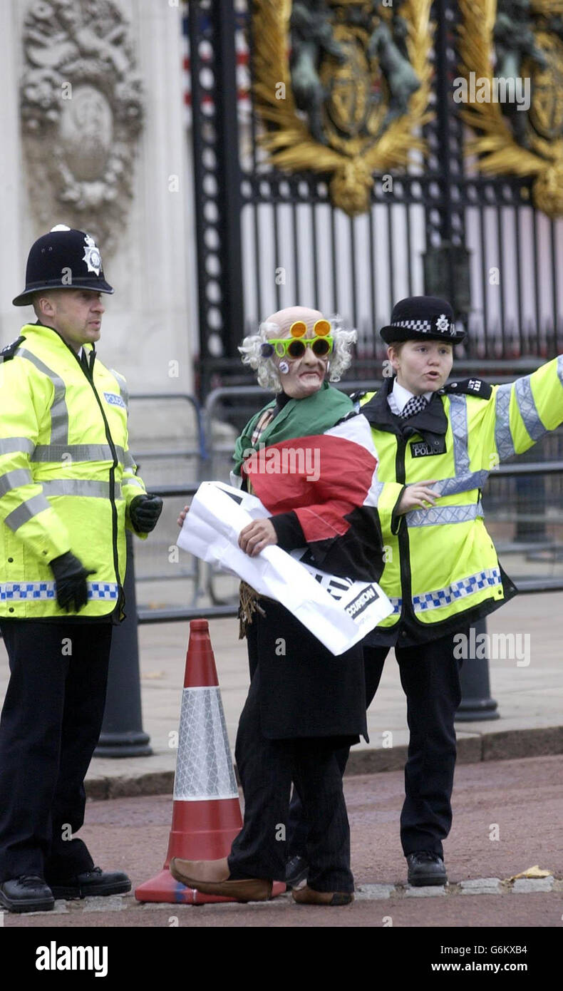 Un manifestant drapé dans un drapeau palestinien est arrêté par la police devant Buckingham Palace à Londres. Une importante opération de sécurité est en place dans la capitale pour la visite d'État du président américain Bush, qui reste au Palais en tant qu'invité de la Reine. Banque D'Images