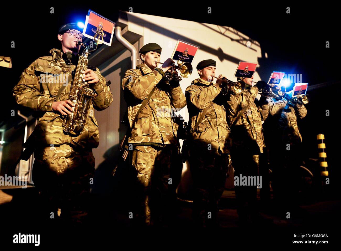 Des soldats se rassemblent à l'hôpital de campagne du Camp Bastion, en Afghanistan, pour un service de chants de noël dirigé par le chœur médical de la Force interarmées du Royaume-Uni, avec de la musique de la bande de l'Artillerie royale. Banque D'Images