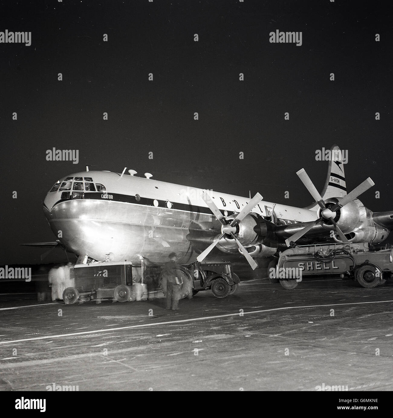 Années 1950, historique, vue de 'Castor' un Boeing 377 stratocruiser de la BOAC en cours d'entretien des avions sur une piste de nuit, un avion de la British Overseas Airways Corporation. Banque D'Images