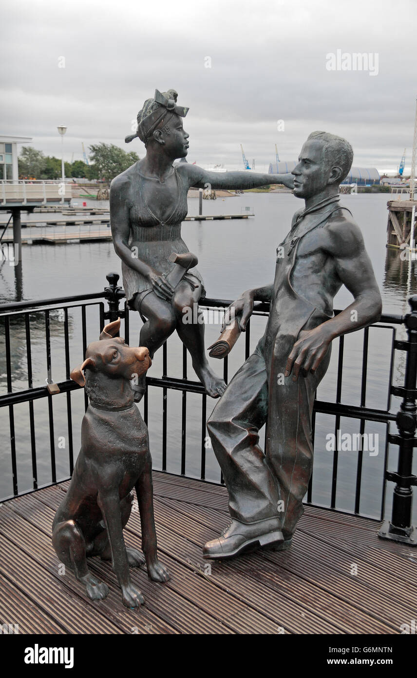 "Des gens comme nous", un groupe de statues d'un homme, femme et chien par John Clinch, Mermaid Quay, la baie de Cardiff, Glamorgan, Pays de Galles. Banque D'Images