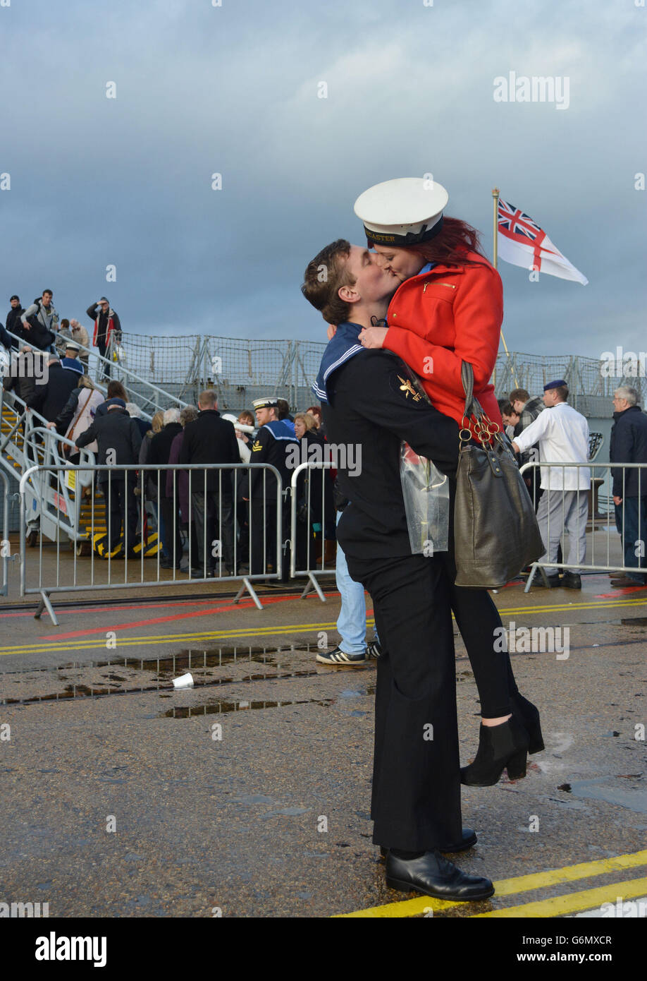 Sam Shannon, 21 ans, originaire de Southampton, Hampshire, fait un baiser à sa petite amie Amber Challis, 19 ans, alors qu'il revient à la base navale de Portsmouth à bord du HMS Lancaster après un déploiement de sept mois de lutte contre la drogue dans les Caraïbes. Banque D'Images