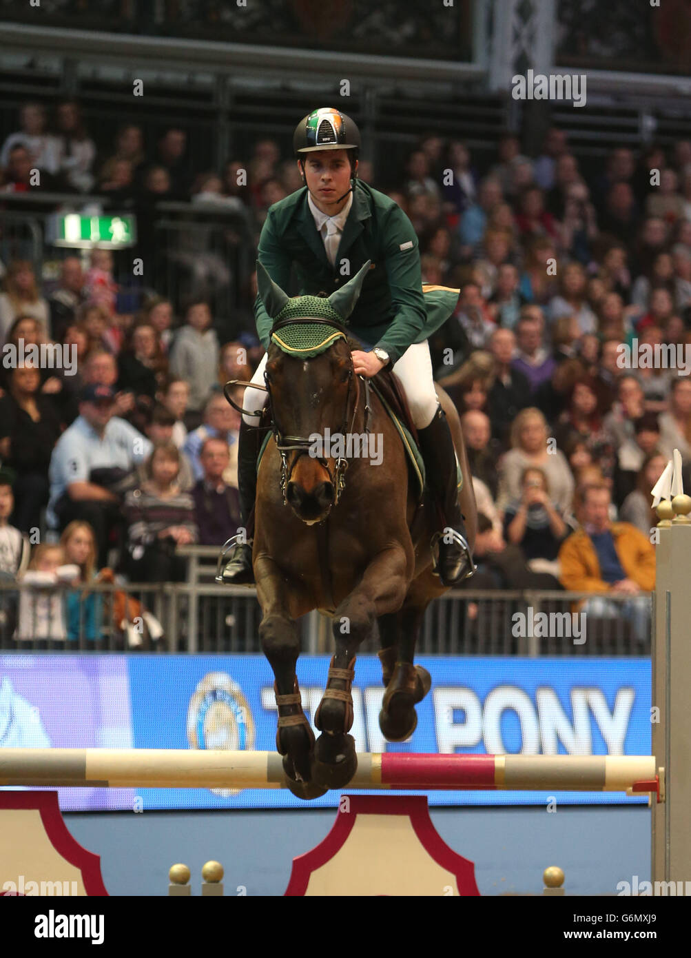 L'Ireland Gerald Clarke, à Zanzibar V, saute une clôture dans le JJ Jumping Pony Club Mini-Major compétition pendant le troisième jour du London International Horse Show, au Olympia Exhibition Hall, West Kensington, Londres. Banque D'Images