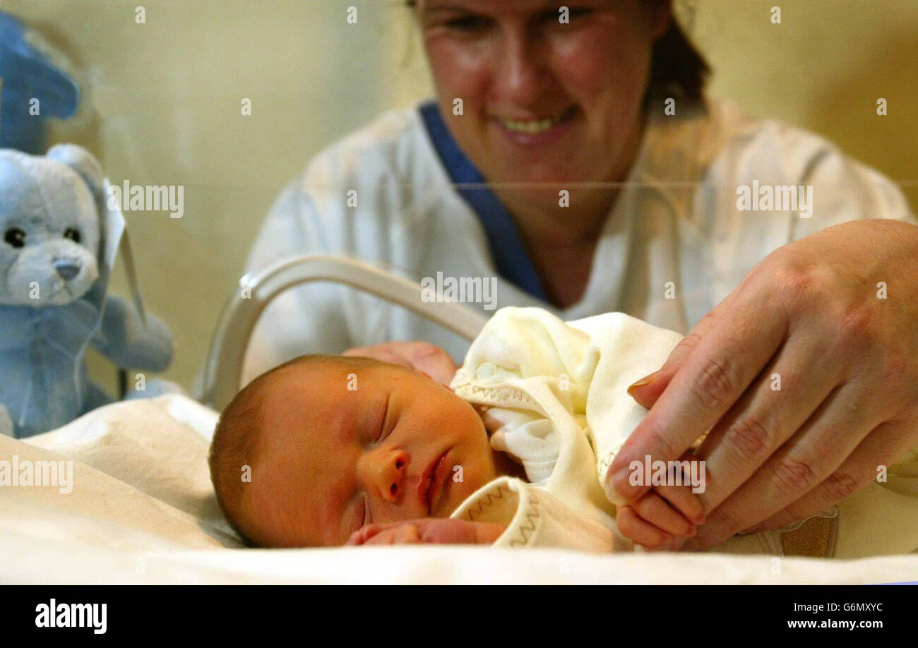 Ward soeur Mary Carlin avec un bébé qui a été découvert par un adolescent à l'extérieur de Mario's fast-food point dans la région de Cardonald de Glasgow, à l'hôpital général du Sud, Glasgow. La police croit que la mère peut avoir besoin d'une assistance médicale urgente et a fait appel à elle pour qu'elle se présente. Banque D'Images