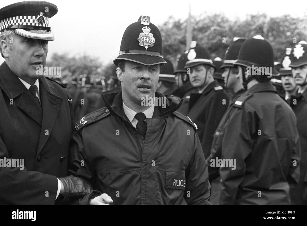 Le sergent de police George Watson est aidé loin de la scène après avoir donné le baiser de la vie à un membre blessé du piquet à l'extérieur de l'usine de coking d'Orgreave près de Rotherham. Banque D'Images