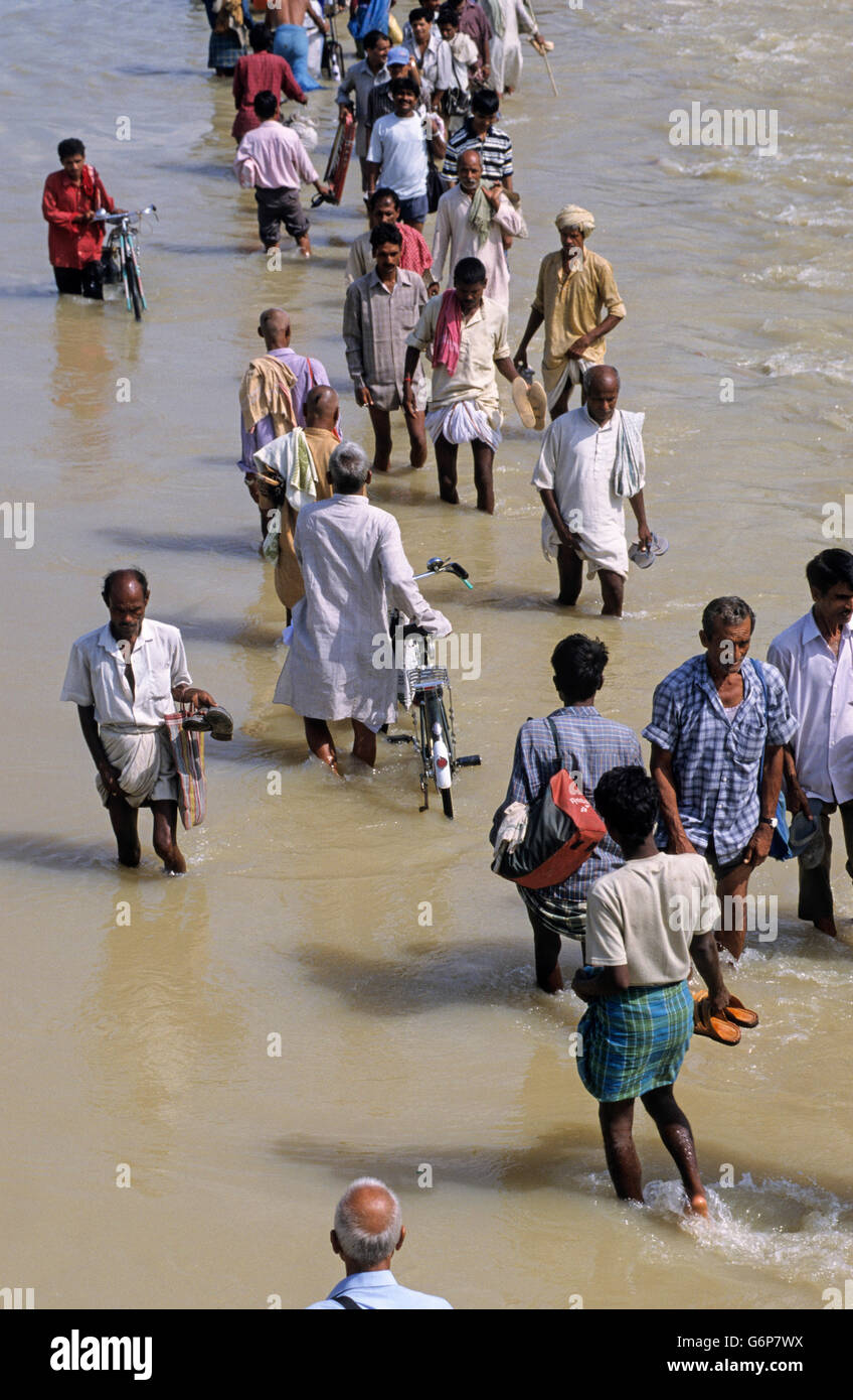 L'INDE, le Bihar, l'ennoiement de la rivière Bagmati, à une succursale de Ganges / Gange due à de fortes pluies de mousson et de la fonte des glaciers de l'Himalaya, pont cassé et endommagé la route, les gens qui marchent dans l'eau, le changement climatique et les effets du réchauffement de la Banque D'Images