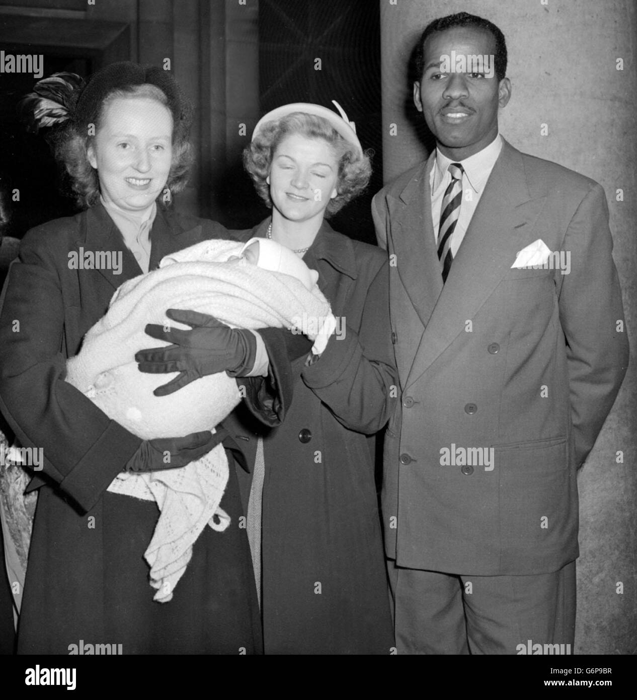 Ruth Khama, épouse de Seretse Khama, tient sa fille-Dieu, Joan Grace Vanessa, fille de l'athlète olympique E. MacDonald Bailey (à droite) après que le bébé vient d'être baptisé à l'église de la Sainte Trinité, Kingsway, Londres. Le centre est Mme Marion Lomas, un autre parrain. Banque D'Images