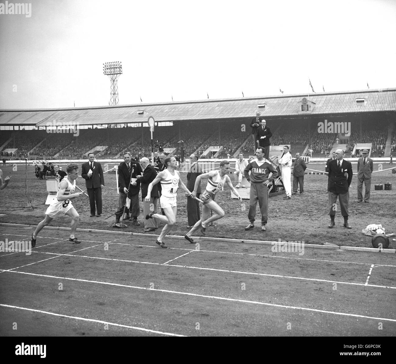 Christopher Chataway remet le bâton à GW Nankeville lors du premier changement de la course relais de 4 x 1 mile entre la Grande-Bretagne et la France au stade White City.L'équipe britannique a gagné avec un temps record. Banque D'Images