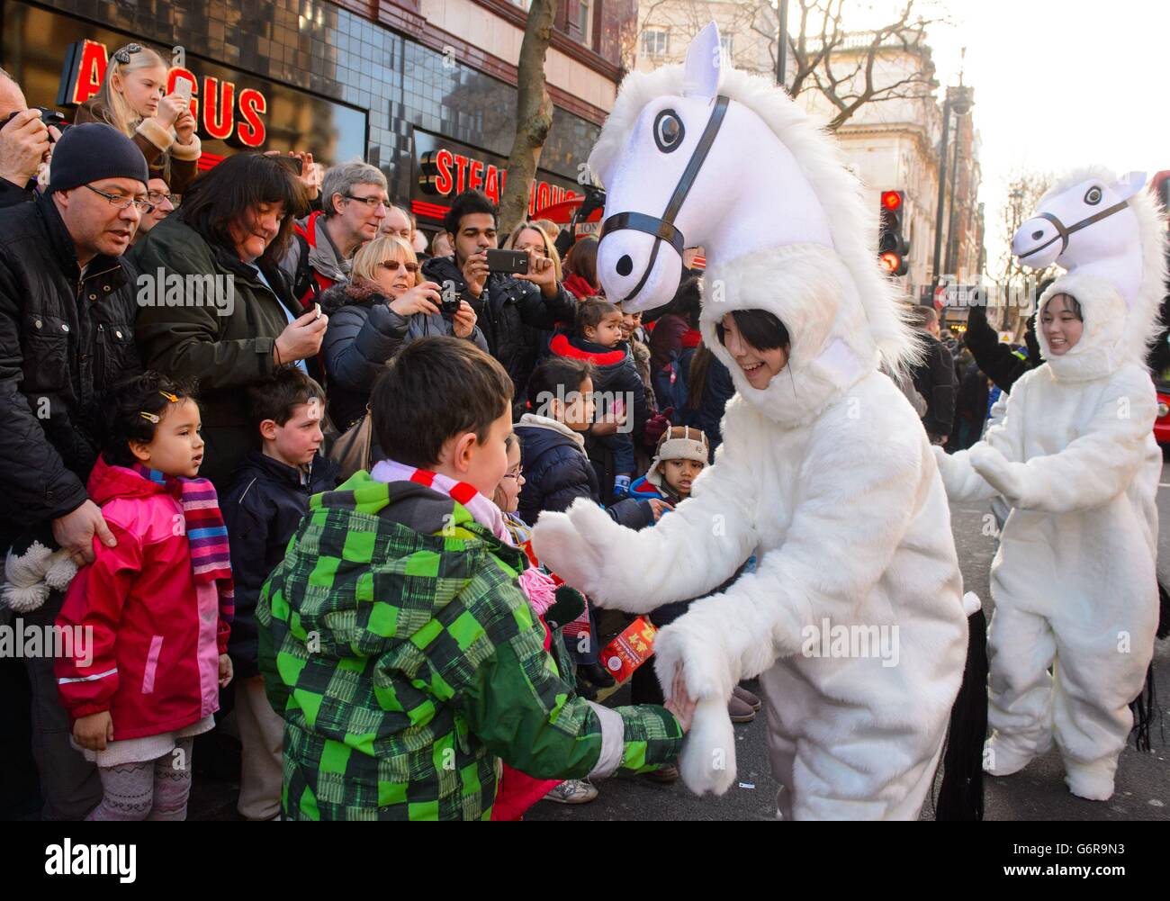 Les artistes en costume accueillent les foules lors du défilé annuel du nouvel an chinois dans le centre de Londres, marquant ainsi le début de l'année du cheval. Banque D'Images