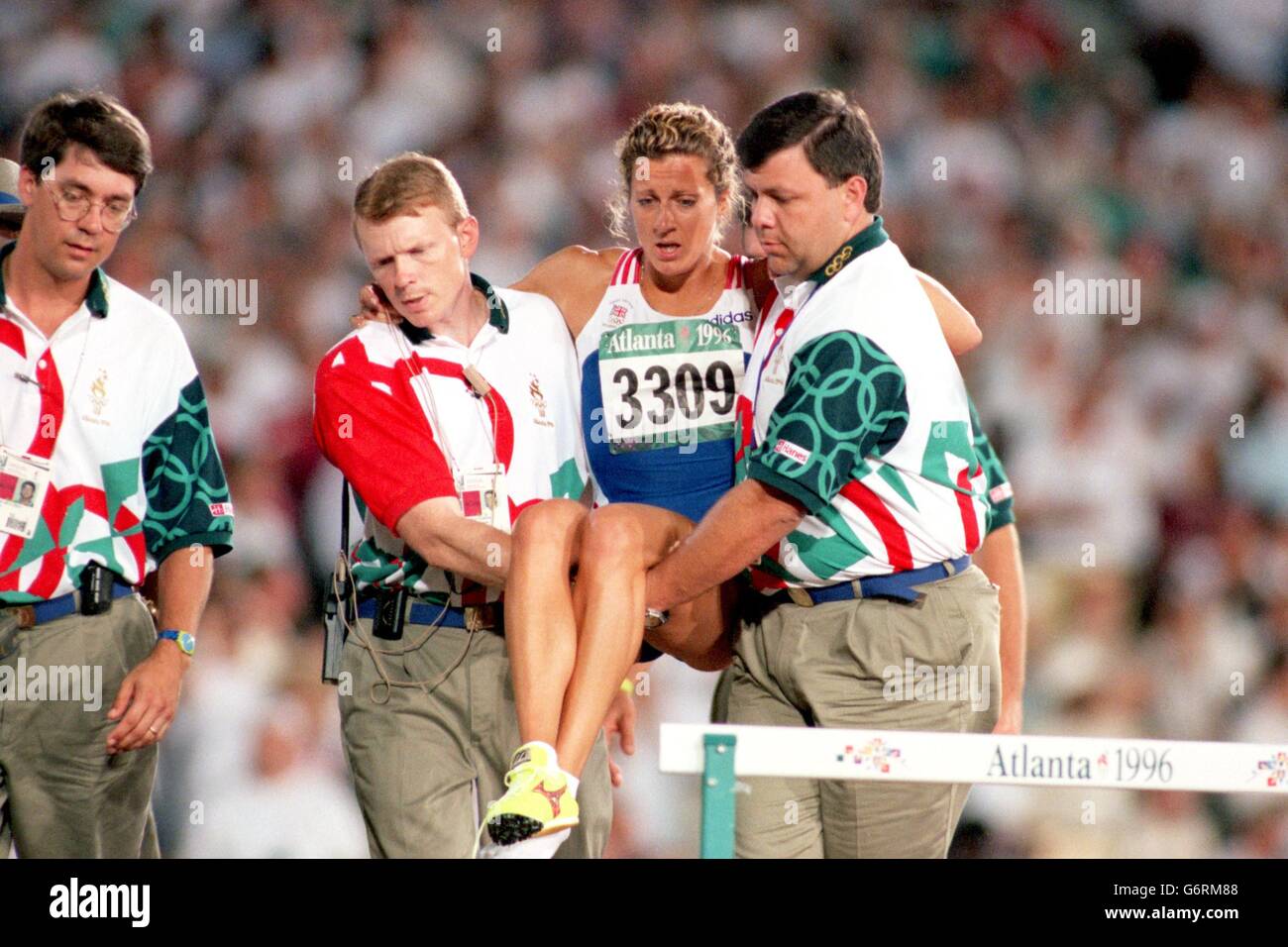 29-JUL-96, Jeux Olympiques d'Atlanta, femmes's 400m haies Heats, la Grande-Bretagne Sally Gunnell est effectuée par des fonctionnaires après avoir été blessé Banque D'Images