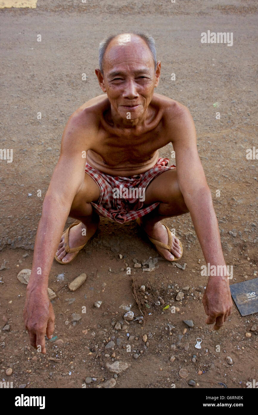 A 78 ans, l'homme est assis sur une rue de village Chork, Cambodge. Banque D'Images