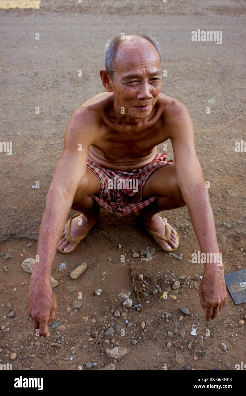 A 78 ans, l'homme est assis sur une rue de village Chork, Cambodge. Banque D'Images