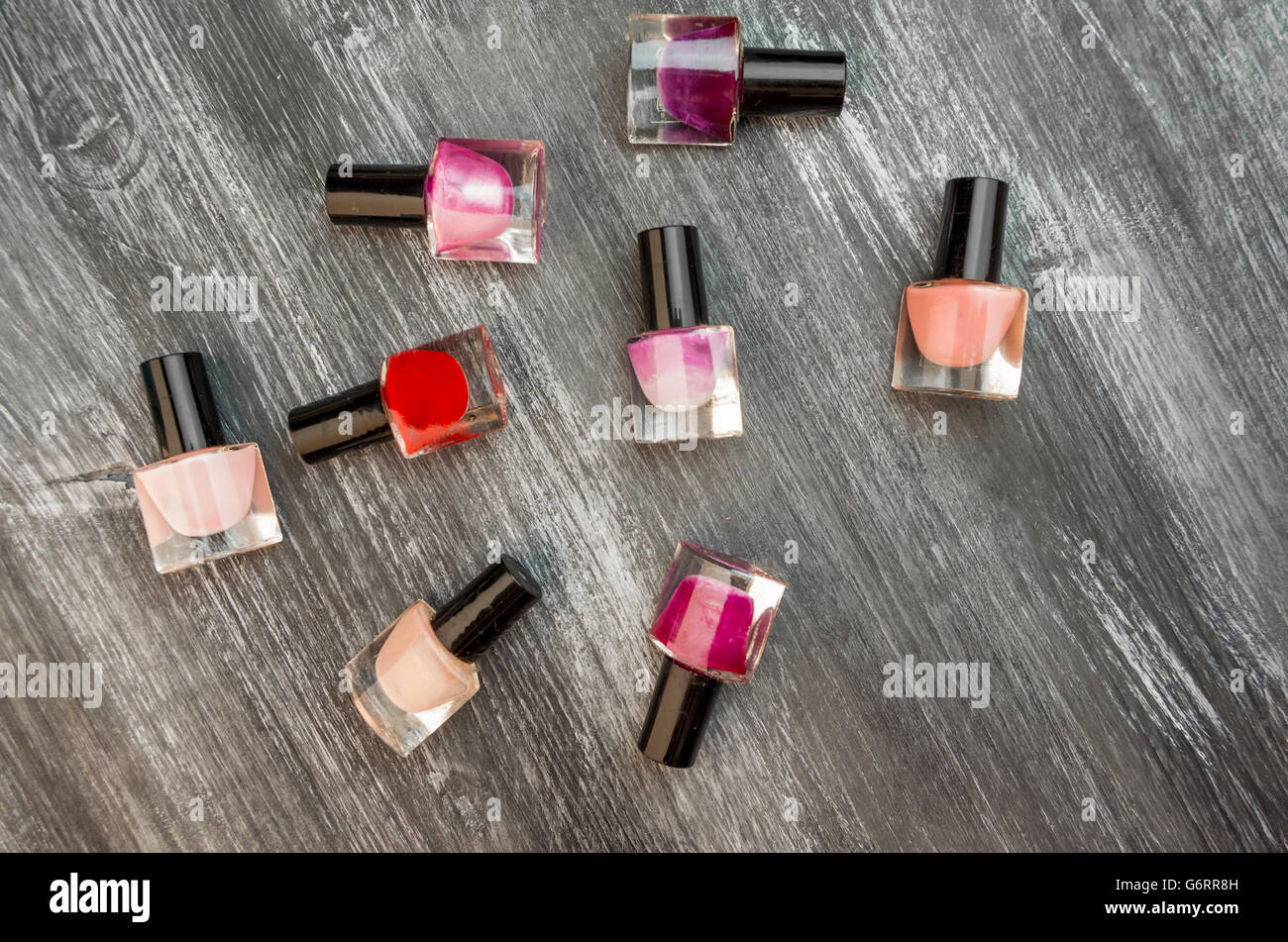 Bouteilles d'ongles polish sur une table en bois gris Banque D'Images