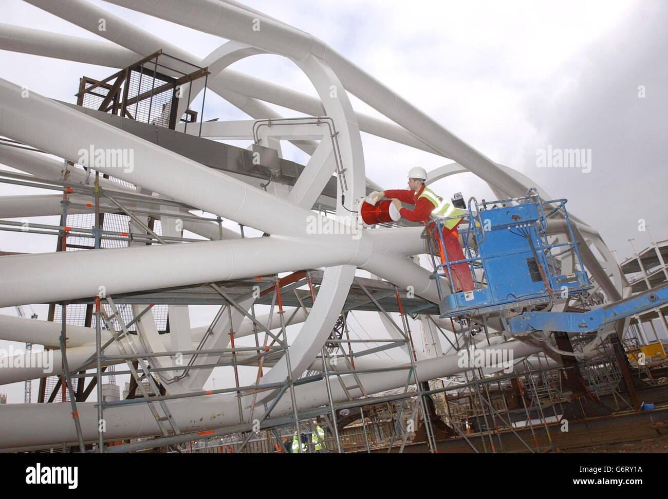 L'électricien Danny Cunningham polit la balise aérienne au sommet de l'arche lors de la construction du nouveau stade Wembley à Londres.Le nouveau stade, qui est en cours de construction sur le site de l'ancien stade Wembley dans le nord-ouest de Londres, devrait être achevé début 2006 et accueillir 90,000 spectateurs. Banque D'Images