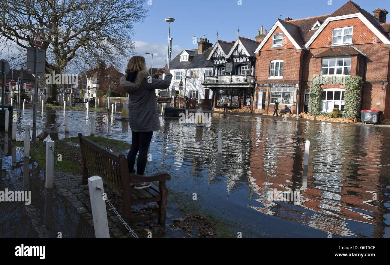 Un résident prend une photo dans le centre du village suite à une inondation à Datchet, Berkshire. Banque D'Images