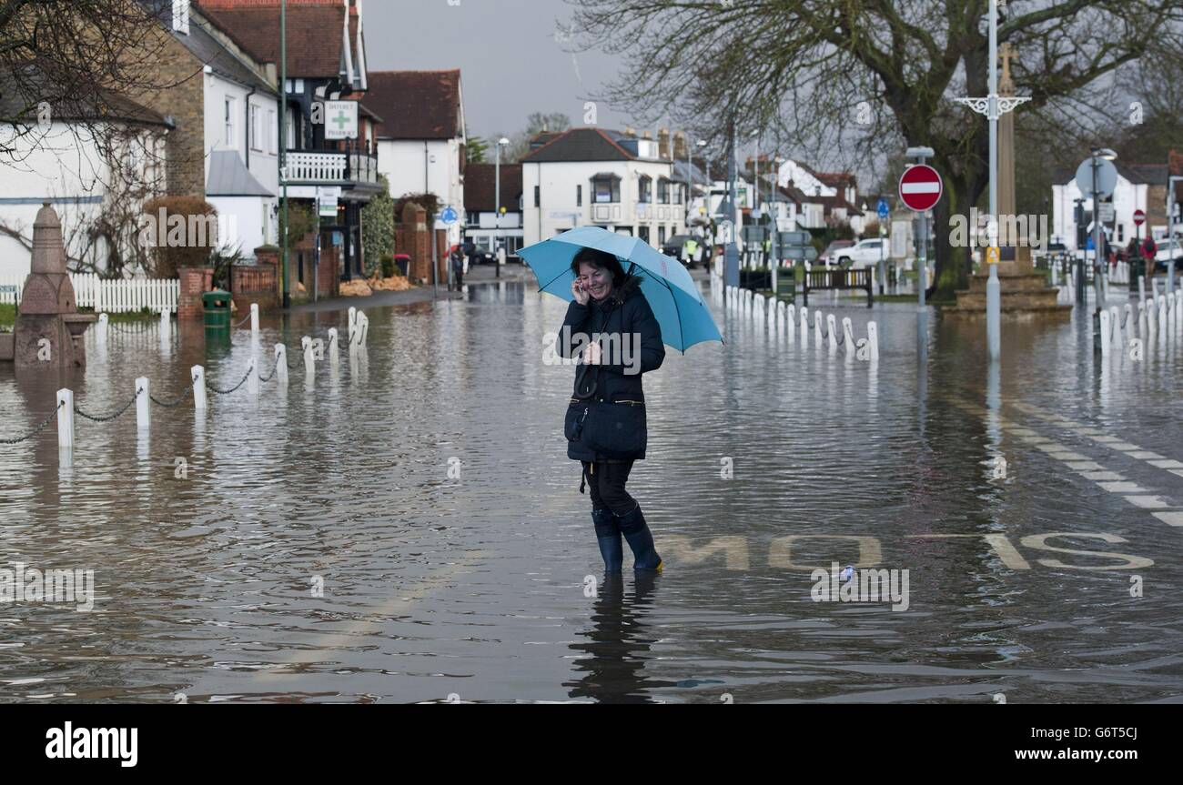 Un résident traverse le centre du village après une inondation à Datchet, dans le Berkshire. Banque D'Images