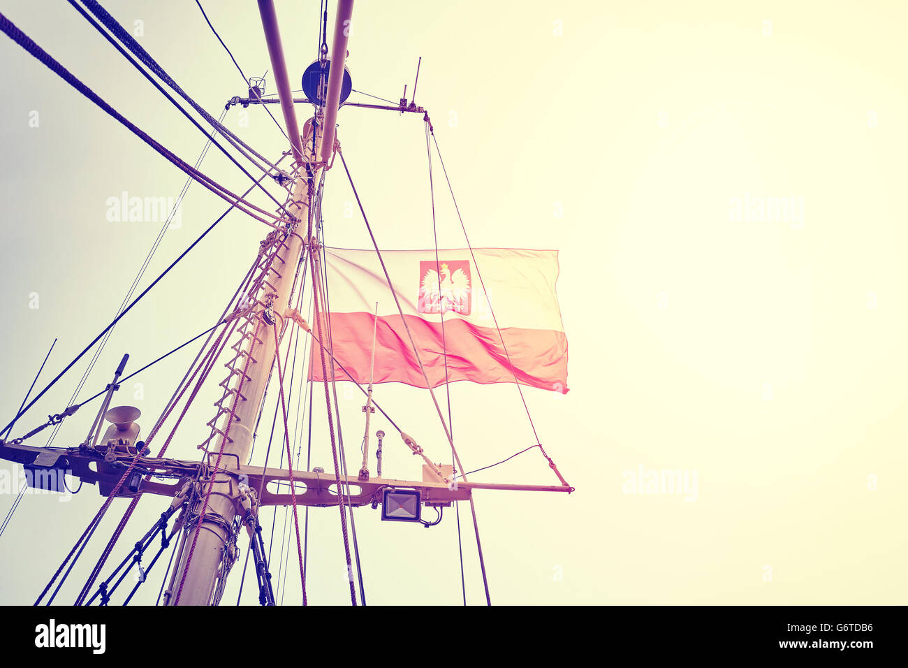 Tons Vintage drapeau polonais sur un voilier mât au coucher du soleil. Banque D'Images