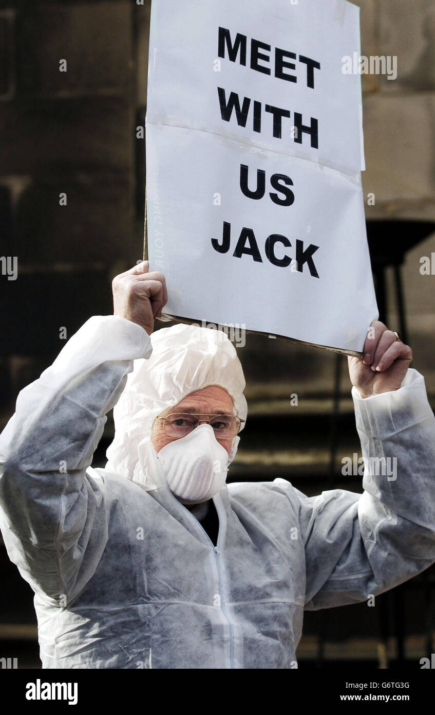 Un manifestant tient une bannière devant le Parlement écossais à Édimbourg. Plus de 40 résidents de quatre villages du Lanarkshire, qui affirment avoir été refusés à rencontrer le Premier ministre Jack McConnell, se sont rendus à Édimbourg en autocar pour un rassemblement de protestation devant le Parlement écossais. Banque D'Images