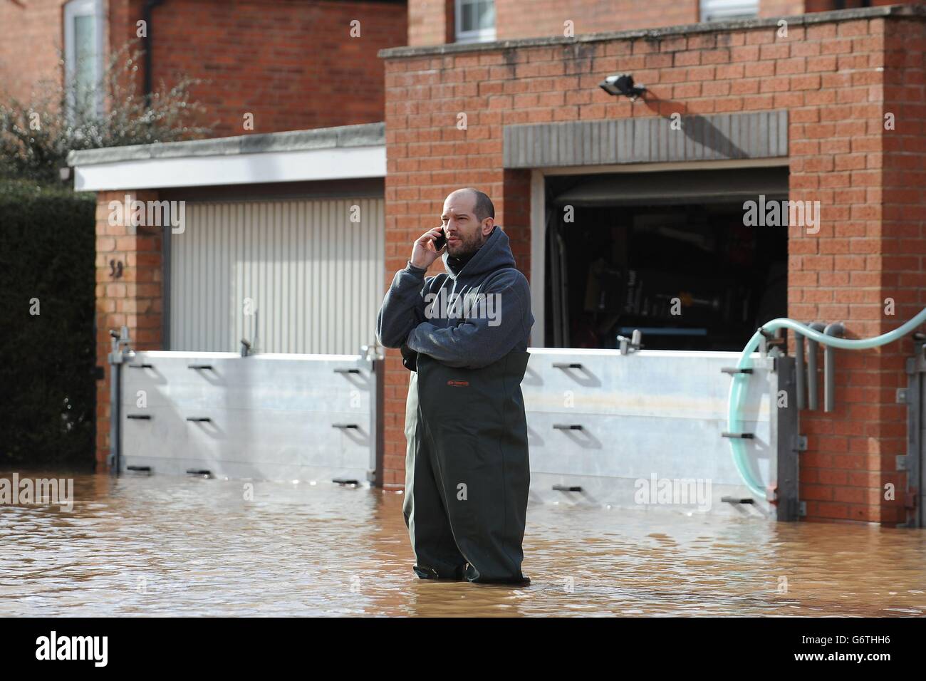 Christian Gander se trouve dans les eaux de crue à l'extérieur de sa maison, sur Waterworks Road à Worcester. Banque D'Images