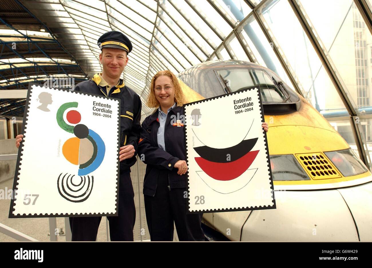 Chris long (à gauche) de Royal Mail a le goût de la vie en tant que postier français à la gare de Waterloo à Londres, avec la positaire britannique Nancy Bryant, pour lancer un numéro de timbre conjoint avec la poste, marquant le centenaire de la signature de l'Entente Cordiale à Londres le 8,1904 avril. Les timbres Entente Cordiale sont en vente au Royaume-Uni et en France le mardi 6 2004 avril pour coïncider avec le début de la visite d'État britannique de la reine Elizabeth II en France. Le timbre de gauche est une œuvre de Sonia Delaunay appelée Coccinelle. Le timbre à droite est de l'artiste abstrait Sir Terry Frost appelé Lace 1. Banque D'Images