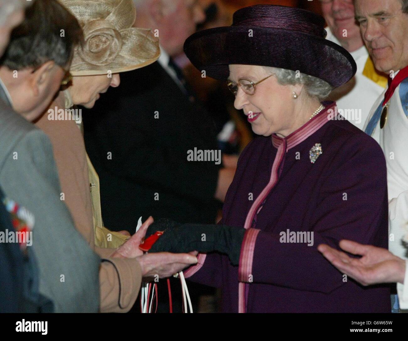 La reine Elizabeth II remet de l'argent à maundy aux pensionnés pendant le Royal Maundy Service tenu à la cathédrale anglicane de Liverpool.La Reine est arrivée à Liverpool, portant un costume violet avec une bordure rose et un chapeau assorti, pour participer à l'ancienne cérémonie du jeudi Maundy. Banque D'Images