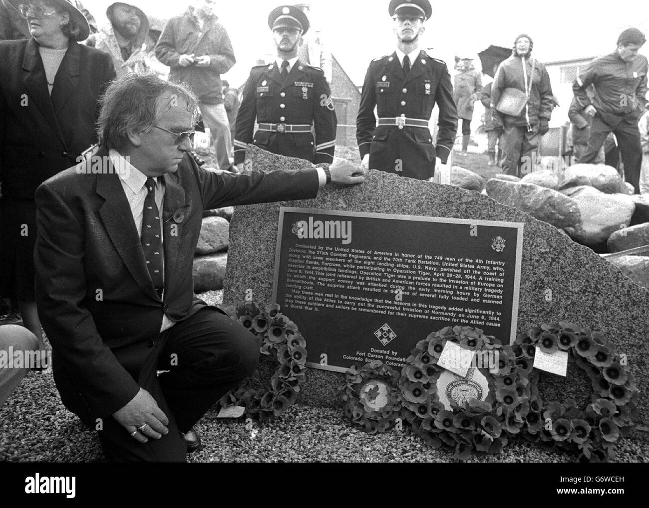Un moment émotionnel pour l'hôtelier de Torcross Ken Small lorsqu'il lit le mémorial dédié à 749 soldats américains qui sont morts dans des répétitions disqueuses pour les débarquements du jour J de 1944, après que la pierre de granit a été dévoilée dans le village côtier de Devon. Banque D'Images