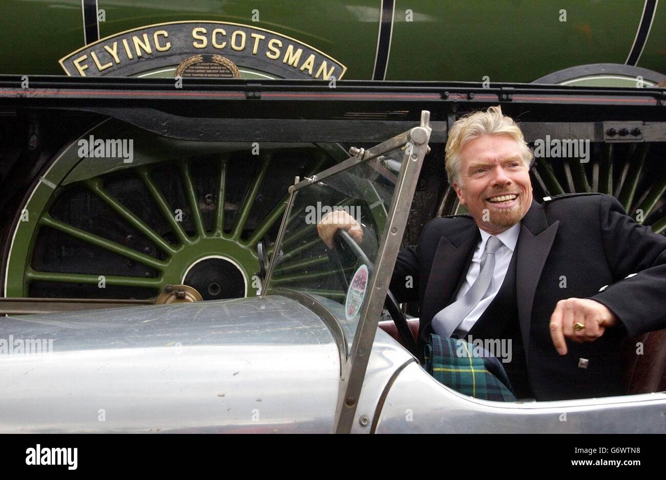Sir Richard Branson est installé dans une voiture Alvis classique à côté du train à vapeur britannique The Flying Scotsman, dans l'ouest de Londres.La crainte que le moteur de 80 ans ne soit vendu à l'étranger a été supprimée après un don de Sir Richard en 365,000, ainsi que des dons publics de 425,000 et 1.8 millions du National Heritage Memorial Fund qui a assuré l'avenir du Loco au Royaume-Uni. Banque D'Images