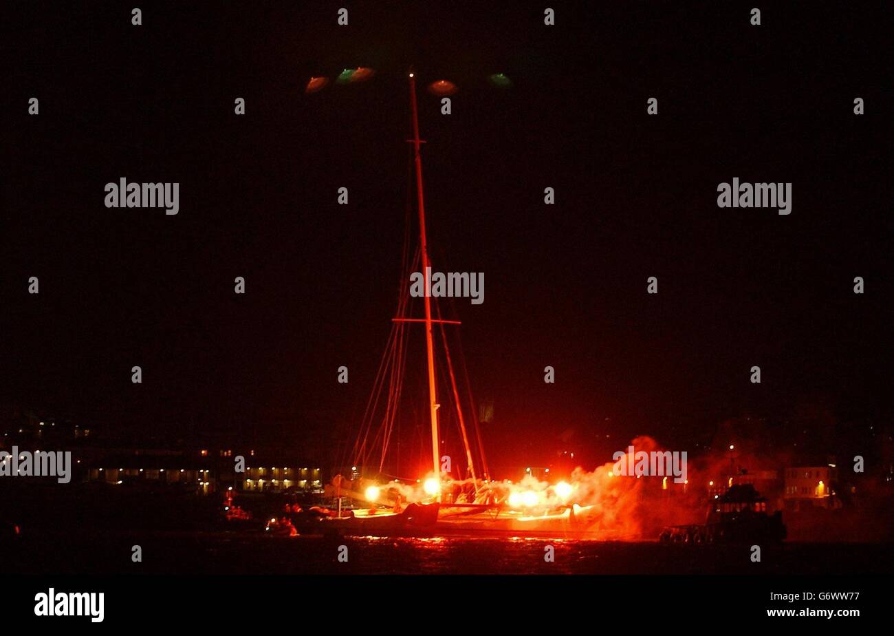 L'équipage record du catamaran Cheyenne arrive à Plymouth à un héros Bienvenue.Une petite foule qui attendait sur la jetée s'est accrochée et a applaudi pendant que le bateau géant a été remorqué à Plymouth juste après 22h.L'aventurier américain Fossett et son équipage de 12 personnes ont écrasé le record mondial de la voile de six jours. Banque D'Images