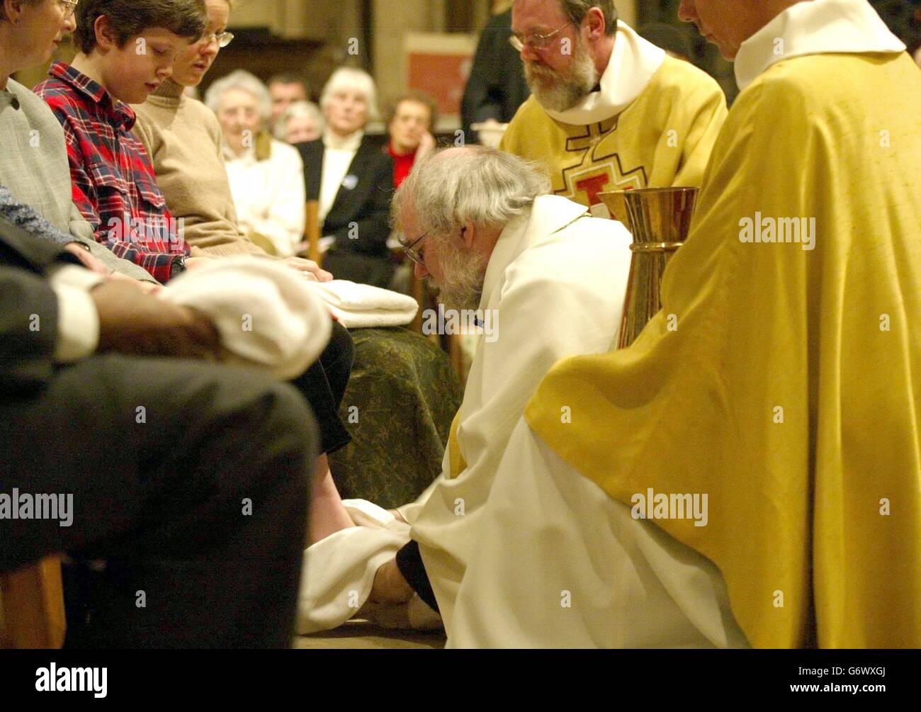 L'Archevêque de Canterbury (au centre), le Dr. Rowan Williams lave les pieds d'un douze adorateurs, jeudi 8 avril 2004, pour recréer Jésus lavant les pieds de ses douze dicièmes dans le cadre du service Maundy à la cathédrale de Canterbury dans le Kent. Banque D'Images