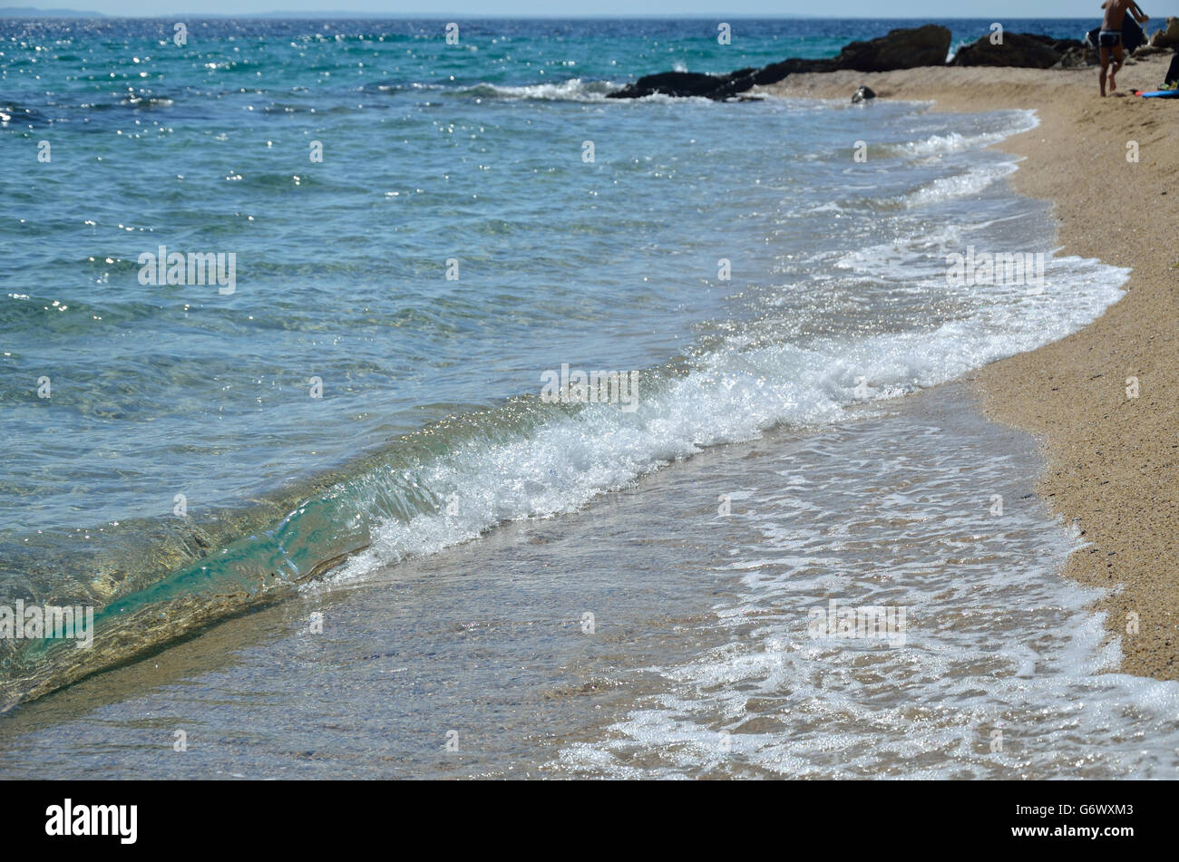 Mer vague mousseuse et people relaxing on beach Banque D'Images