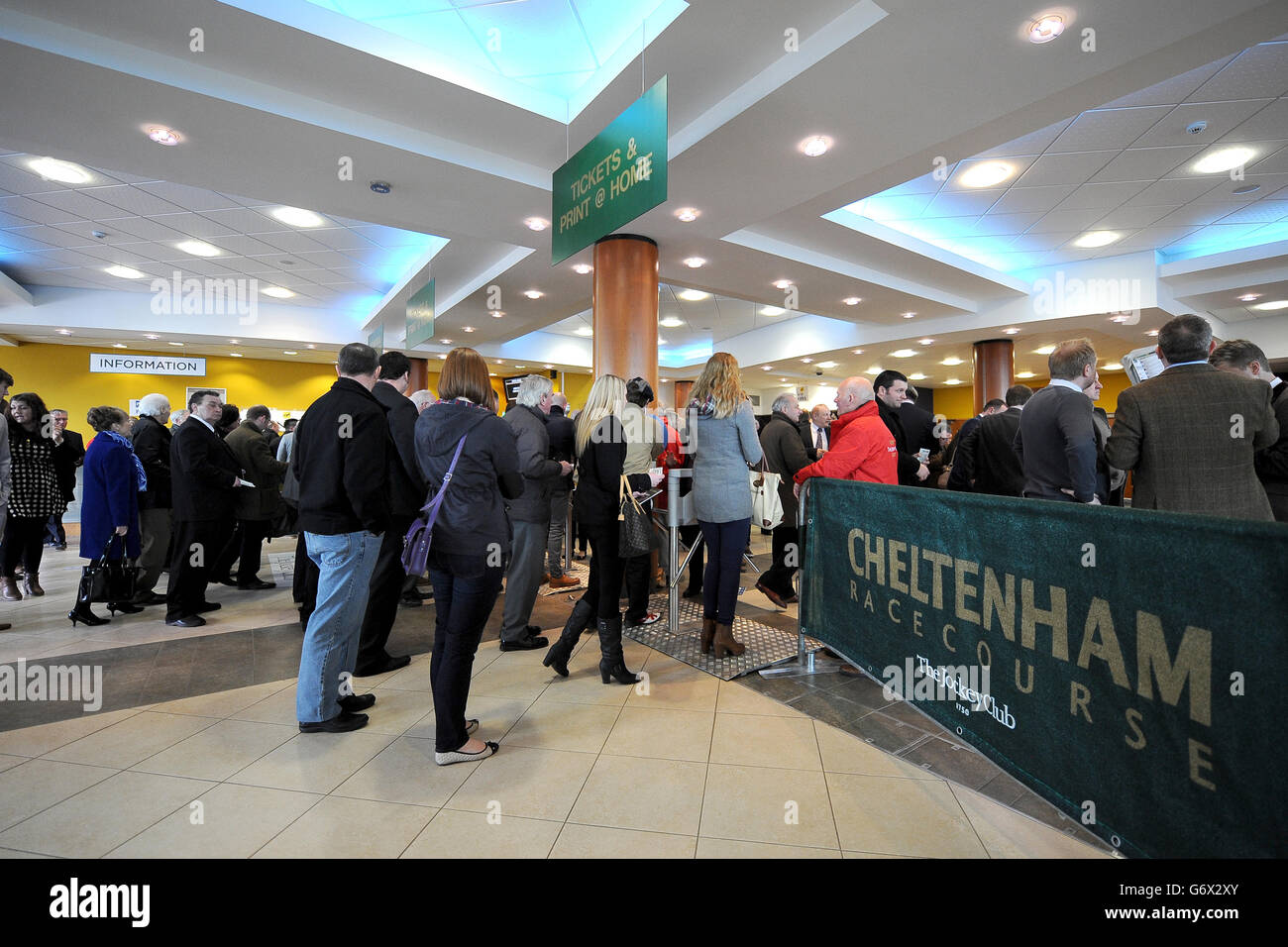 Les gens qui utilisent les tourniquets à l'hippodrome de Cheltenham arrivent pour le premier jour. Banque D'Images