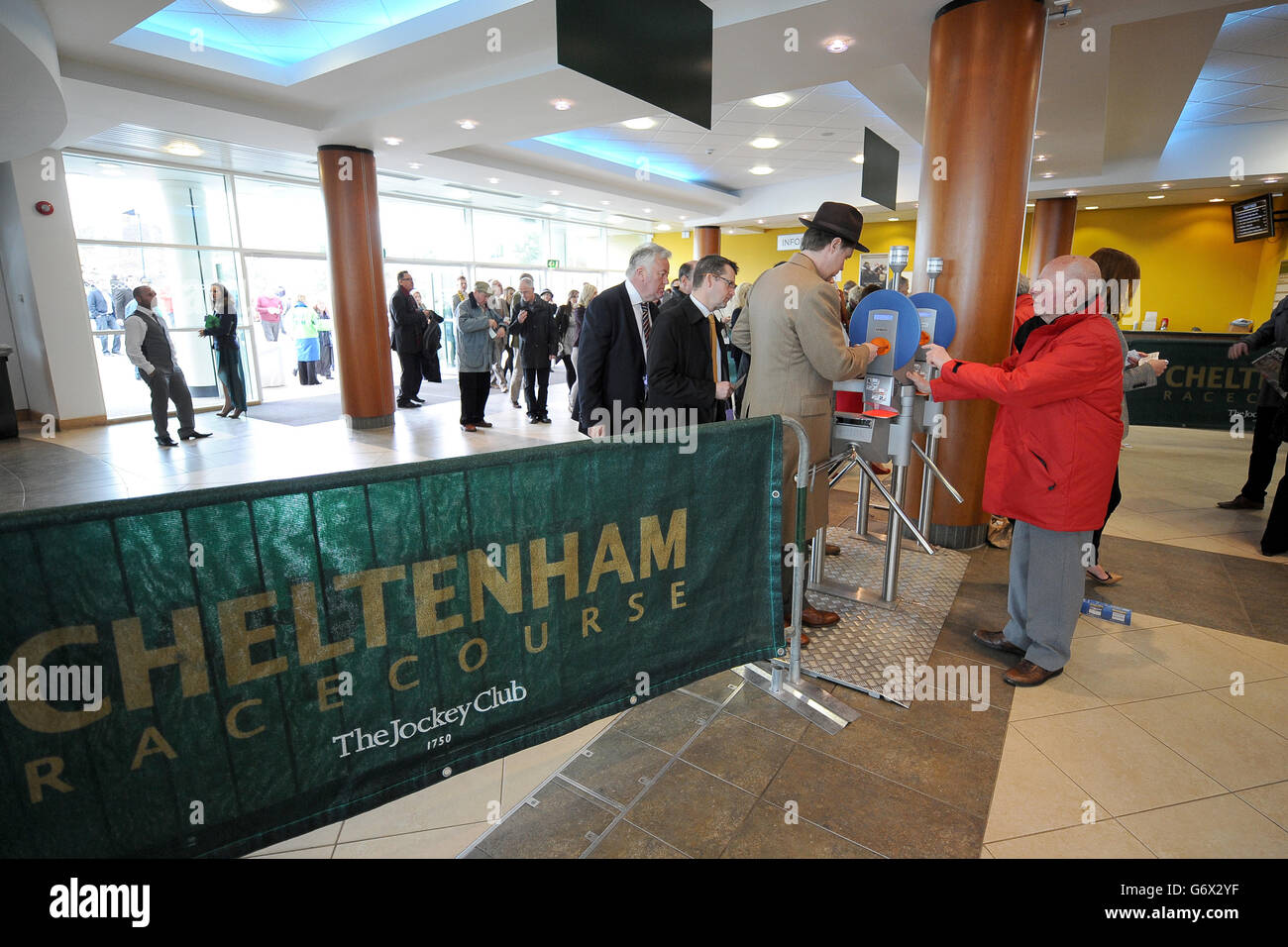 Les gens qui utilisent les tourniquets à l'hippodrome de Cheltenham arrivent pour le premier jour. Banque D'Images