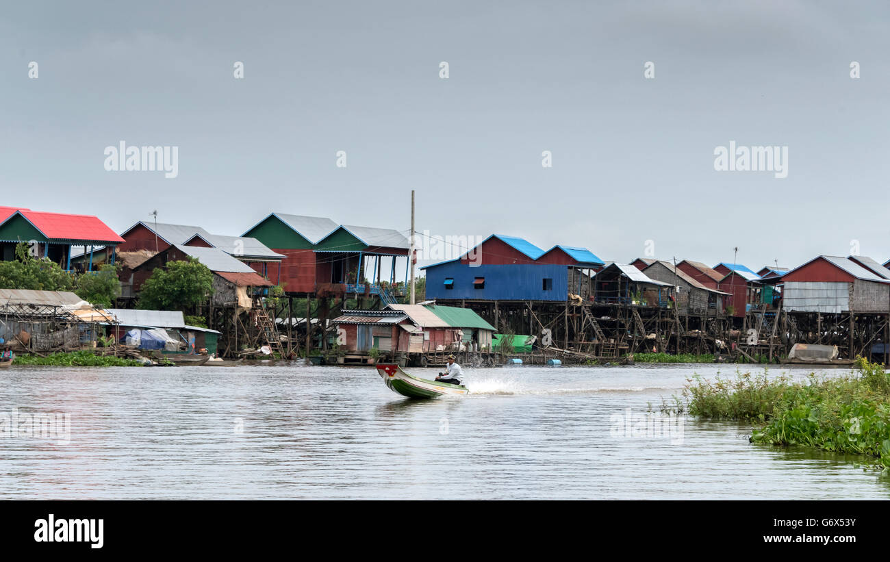 Kampong Phluk maisons sur pilotis avec bateau "long tail, Cambodge Banque D'Images