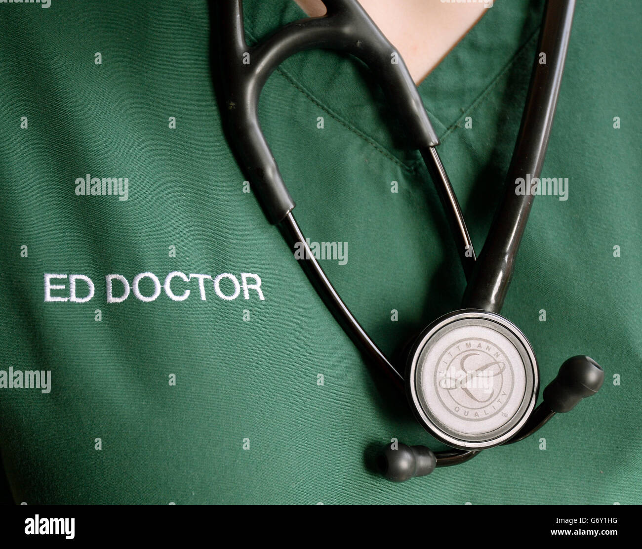 Un modèle pose avec un stéthoscope autour du cou pendant Porter des produits de nettoyage des services d'urgence Banque D'Images