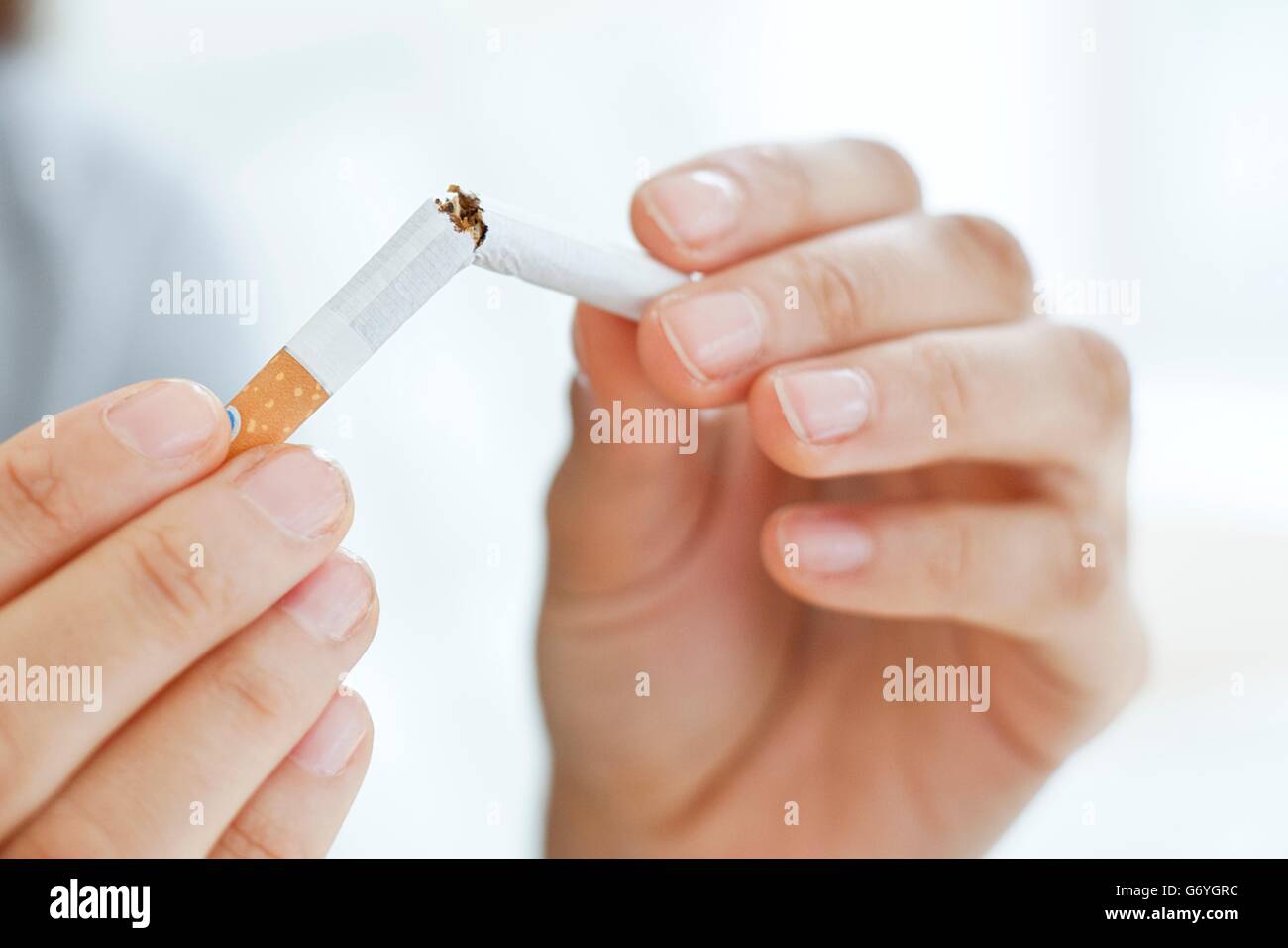 Parution du modèle. Jeune femme briser une cigarette à moitié. Banque D'Images