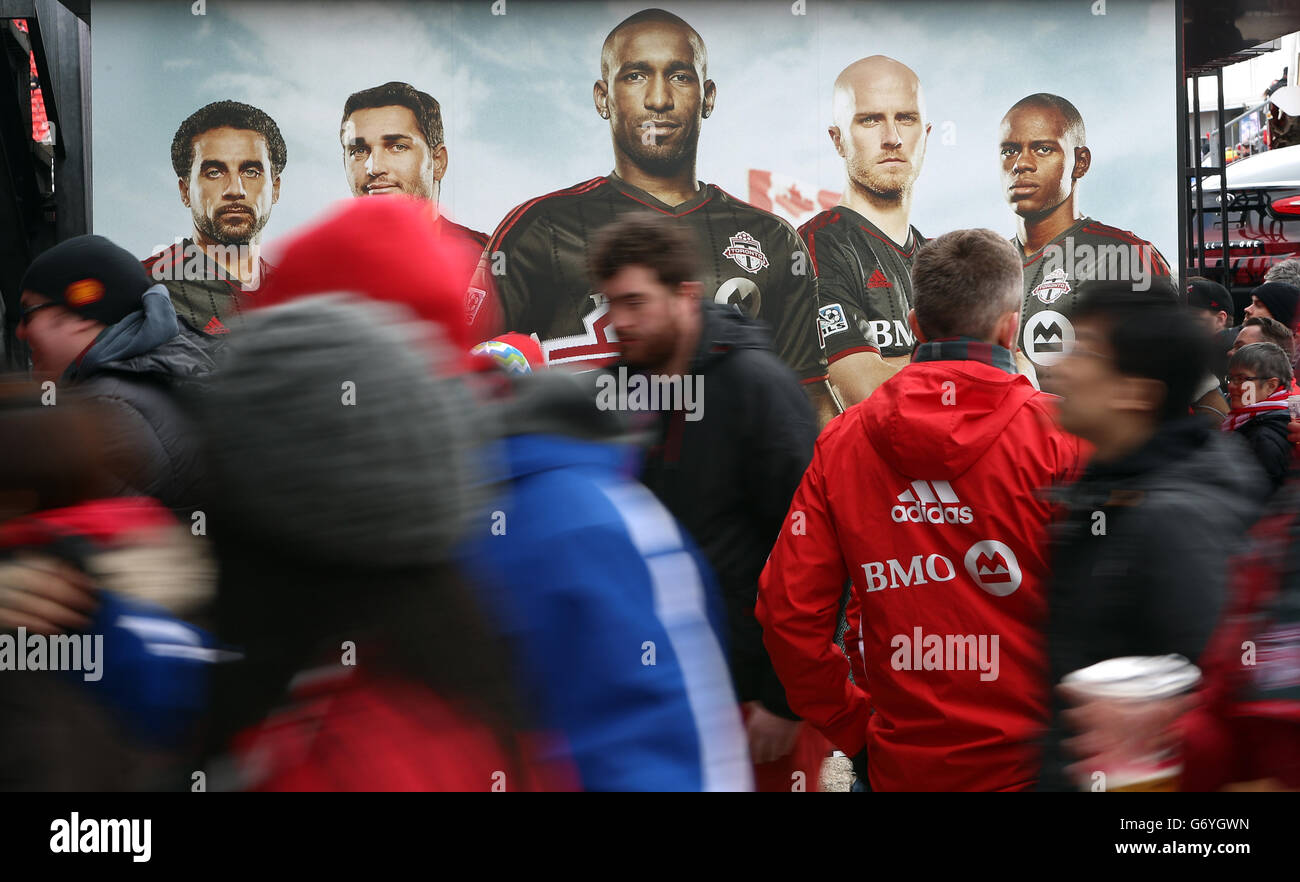 Soccer - Major League Soccer - Toronto FC c. D.C. United - BMO Field.Les fans marchent devant une publicité du Toronto FC. Banque D'Images