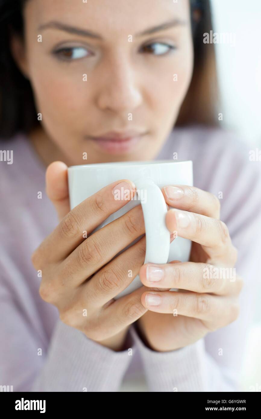 Parution du modèle. Young woman holding mug avec boisson chaude. Banque D'Images