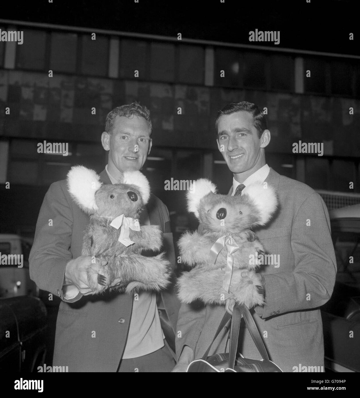 Le capitaine d'Everton Roy Vernon (r) et le coéquipier Sandy Brown avec des mascottes d'ours koala, souvenirs de leur visite réussie du club australien, à l'arrivée à l'aéroport de Londres. Banque D'Images