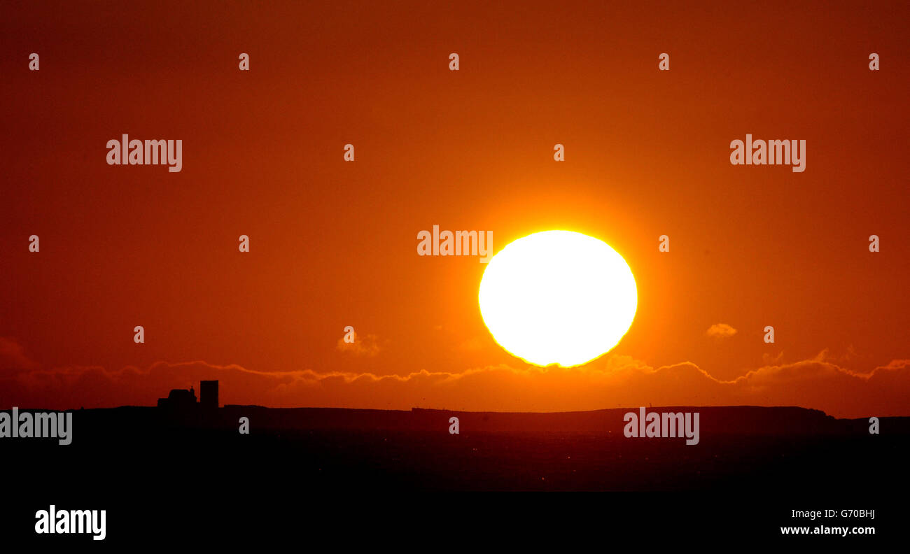 Le soleil se lève au-dessus des îles Farne, au large de la côte de Northumberland, tandis que les températures douces que la plupart des Britanniques ont appréciées au cours des derniers jours se poursuivront la semaine prochaine avant de descendre le vendredi Saint. Banque D'Images