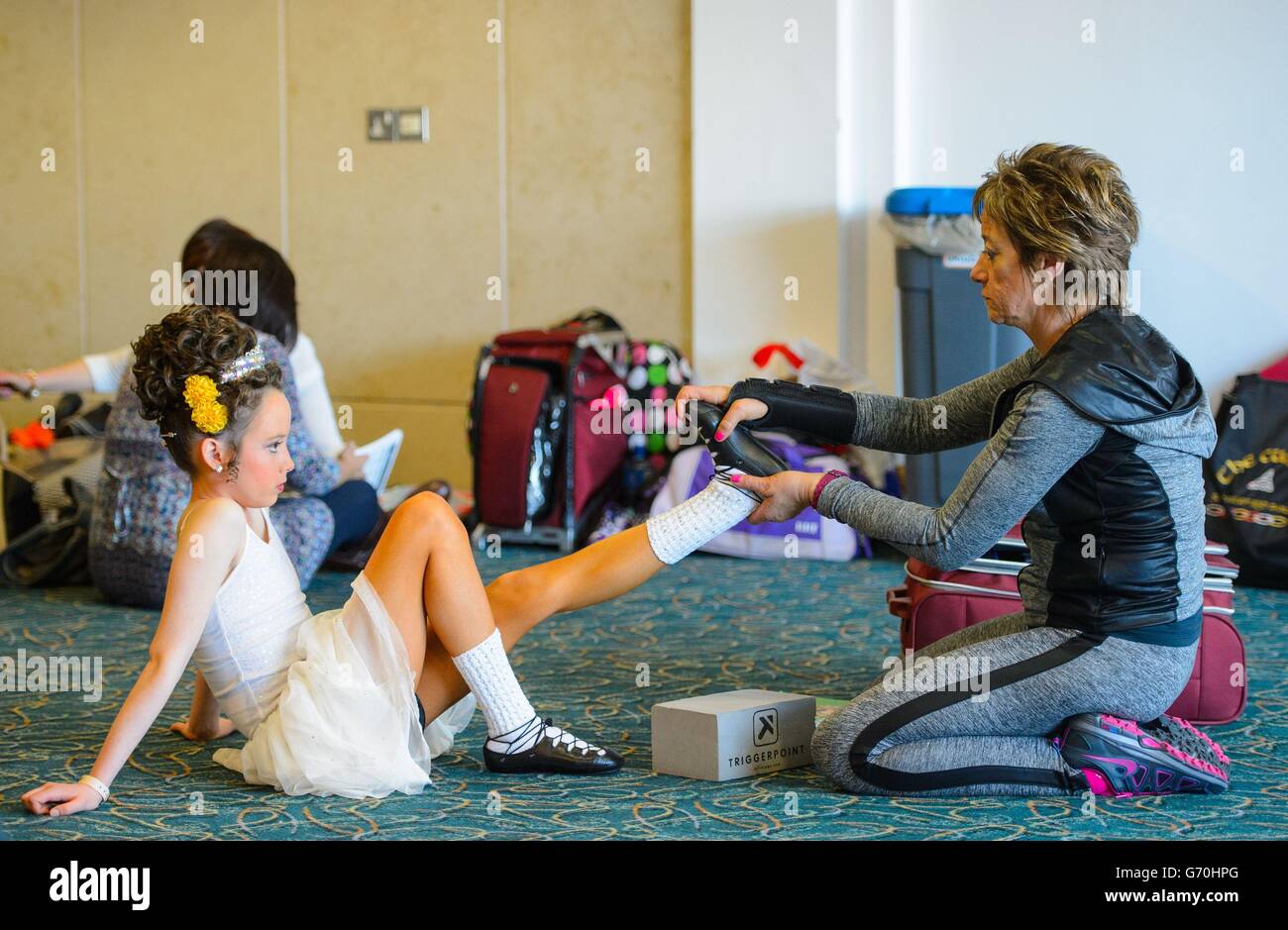 Une danseuse s'étire avant de participer aux championnats du monde irlandais de danse 2014, à l'hôtel Hilton London Metropole, dans le centre de Londres. Banque D'Images