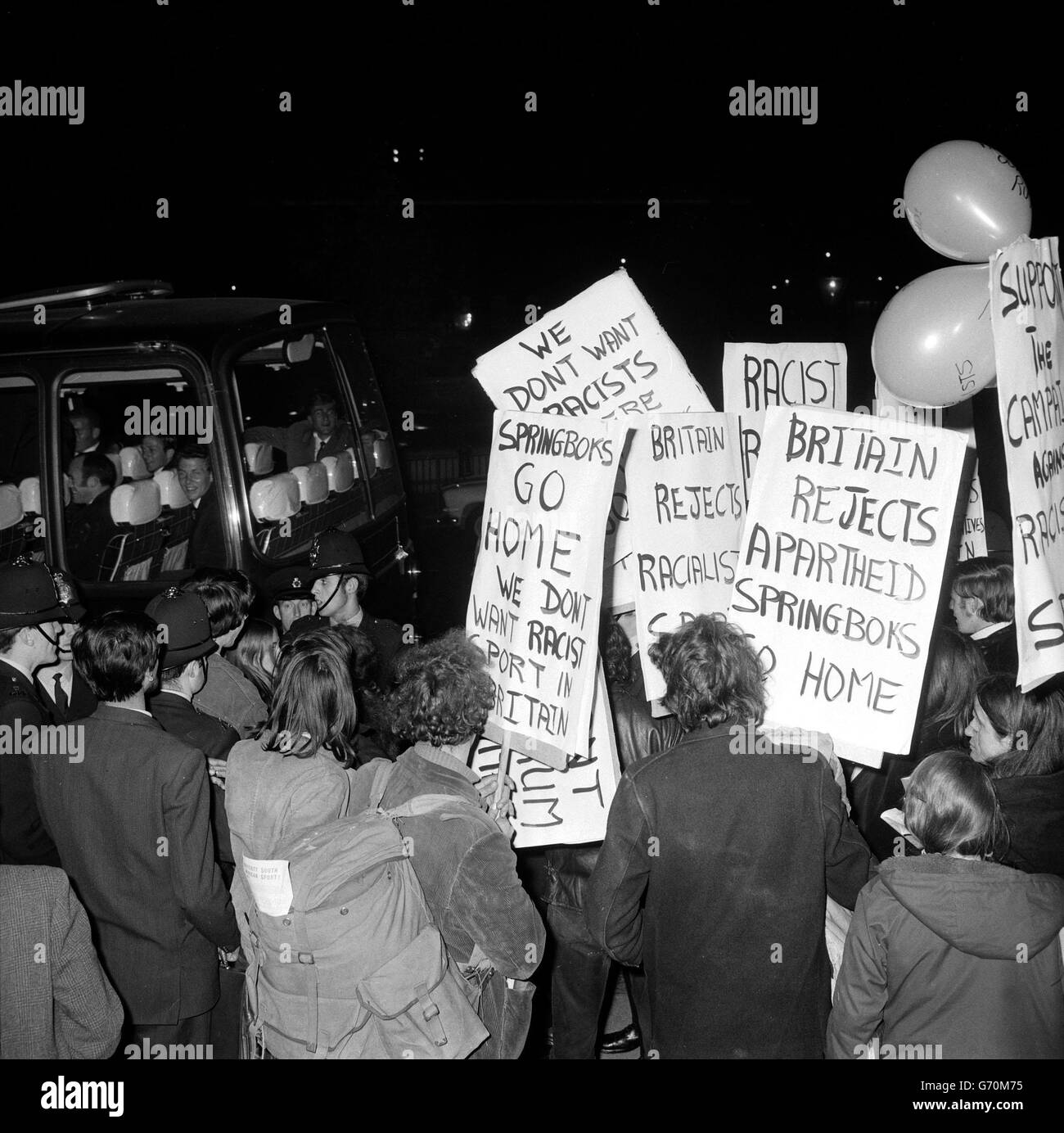 Les manifestants brandisquent des pancartes et donnent de faux salutes nazis aux membres de la fête de tournée en Afrique du Sud alors qu'ils quittent l'ambassade sud-africaine à Trafalgar Square, Londres. Banque D'Images