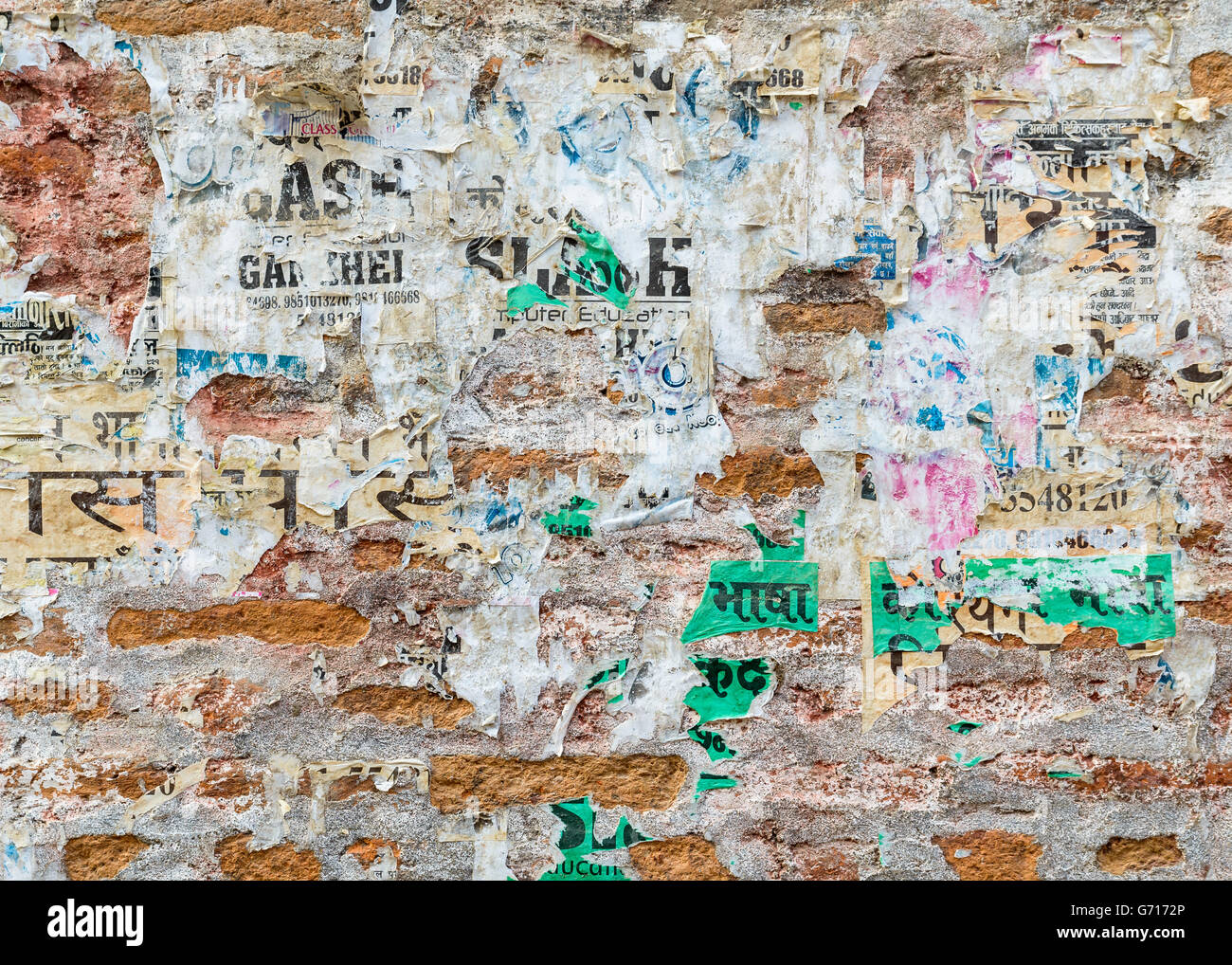 La texture du mur de brique Grungy avec affiches déchirées à Katmandou, Népal Banque D'Images