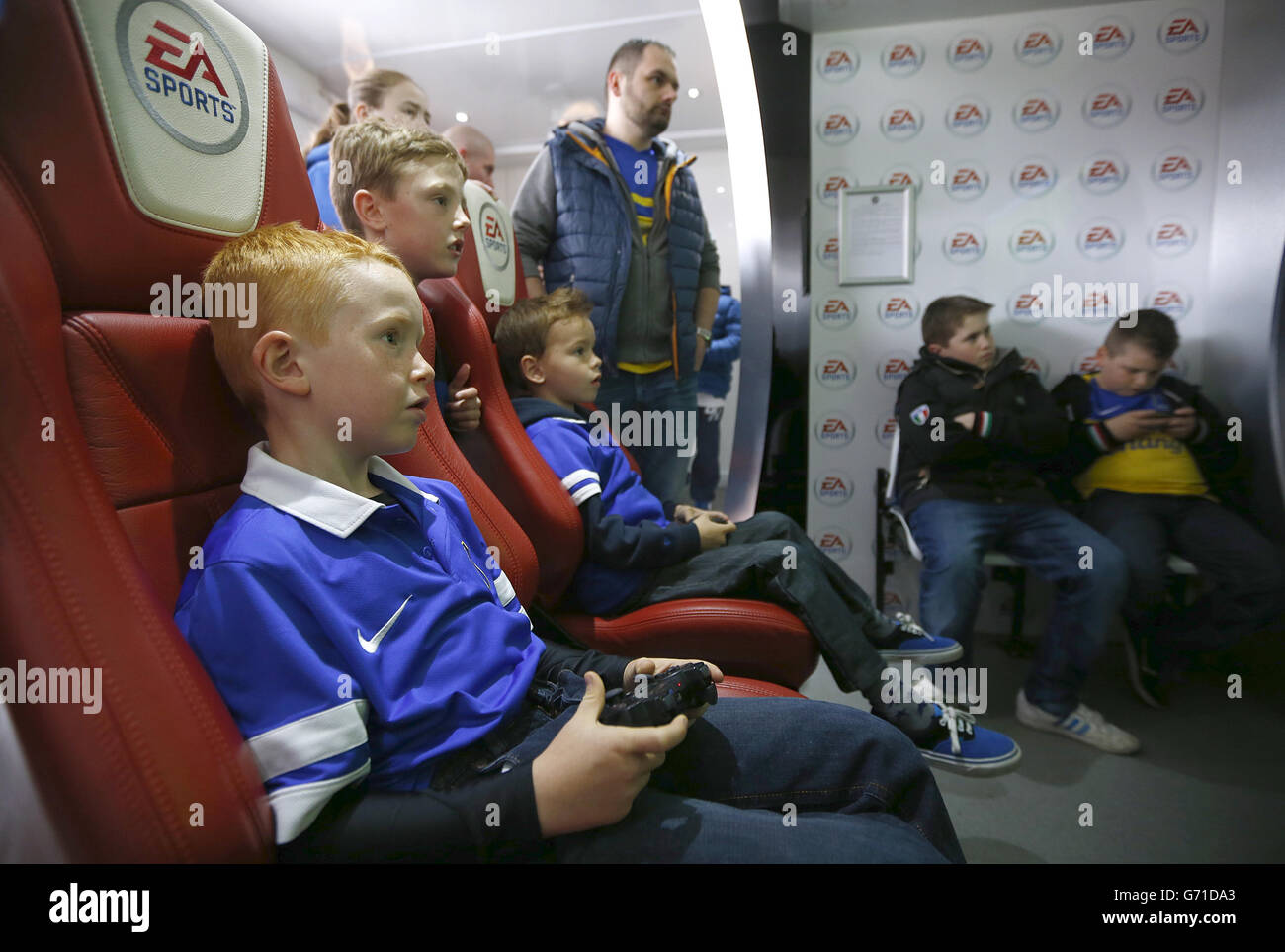 Un jeune fan d'Everton jouant un jeu dans le véhicule sportif EA Banque D'Images