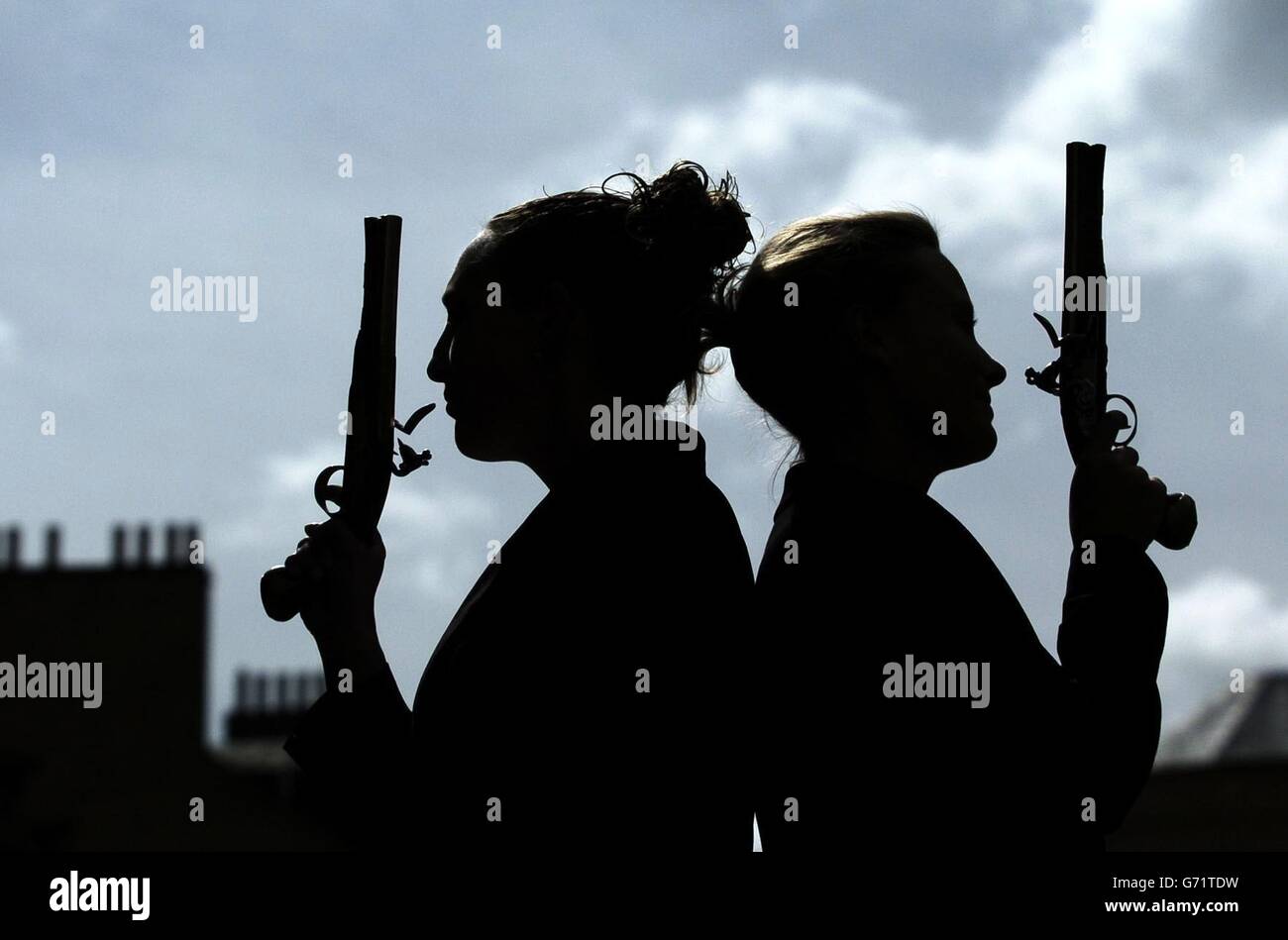 Victoria Crake (à droite) et Amy Lanyon présentent deux pistolets du XVIIIe siècle qui appartiennent à Robert Clive, de l'Inde, d'une valeur de 15,000 et qui seront mis aux enchères par Lyon et Turnbull à Édimbourg le 30 juin 2004. Banque D'Images