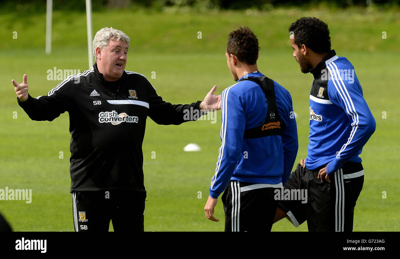 Le directeur de Hull City, Steve Bruce, discute avec Jake Livermore (au centre) et Tom Huddlestone (à droite) lors d'une séance de formation ouverte sur le terrain de formation des équipes à Cottingham, à Hull. Banque D'Images